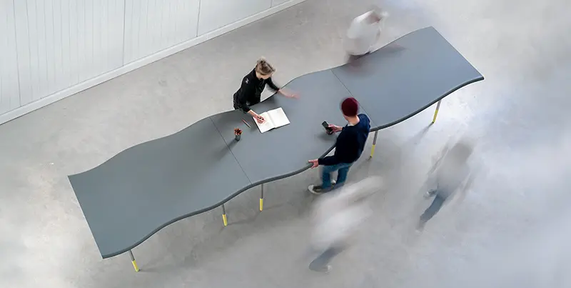 3D printed table from recycled plastic waste with flowing wave-shaped surface